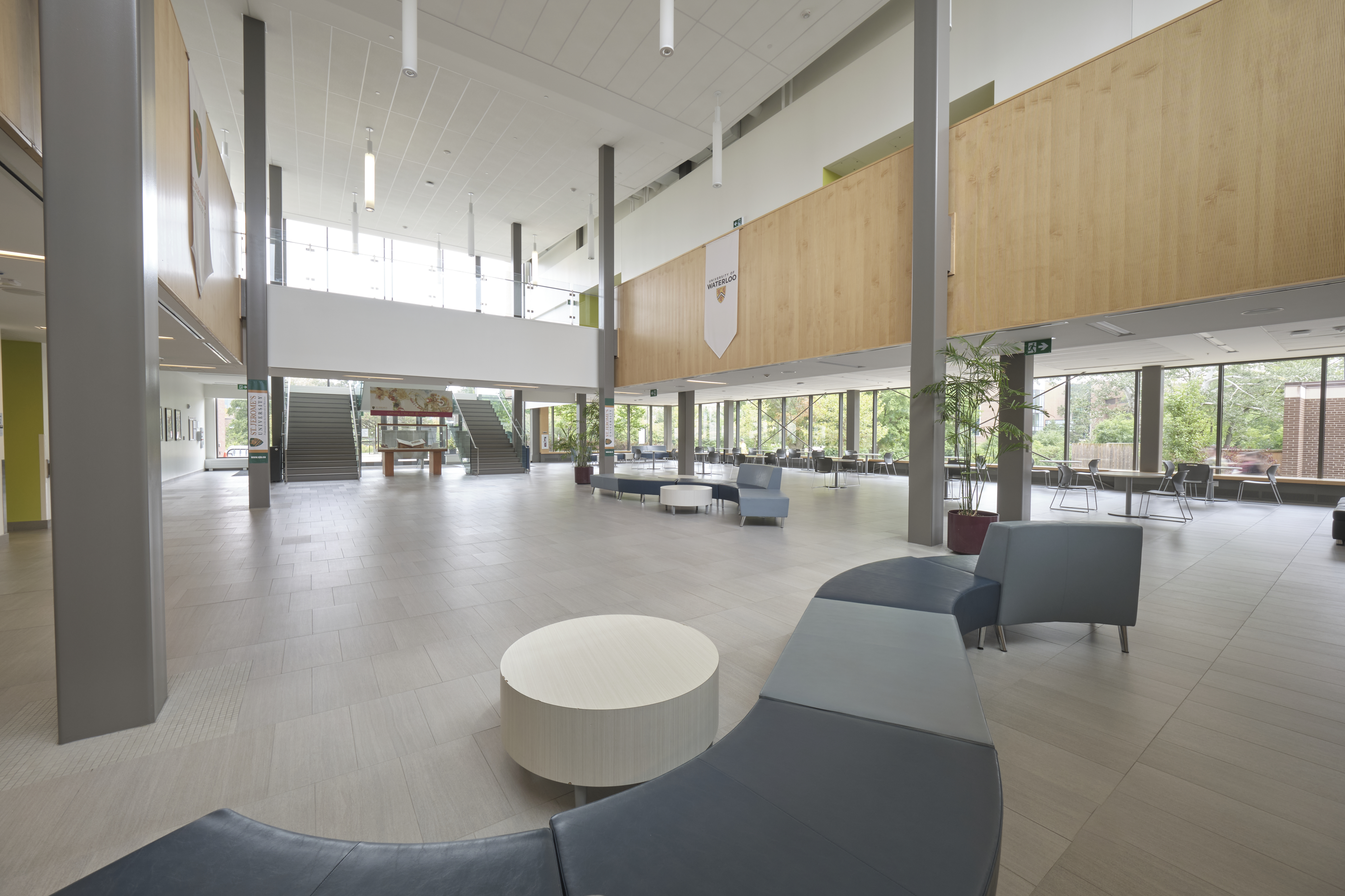 Large, bright, two-story atrium with bench and table seating throughout.