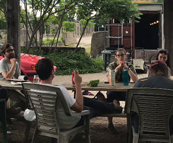 Students gathered under a gazebo taking a break from work